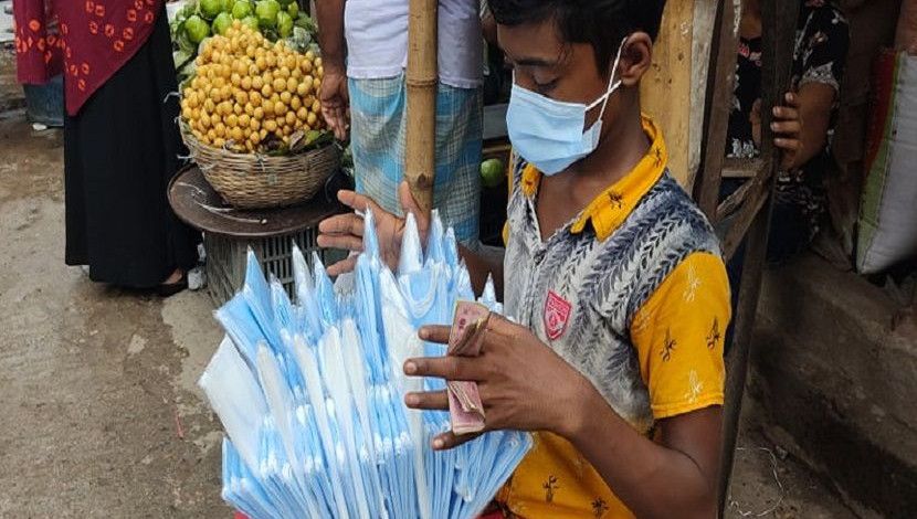 লকডাউনে মাস্ক বিক্রি করছেন অয়ন। ঘরে অসুস্থ মা। বাধ্য হয়ে এসেছেন রাস্তায়। ছবি: জাহিদ রাকিব