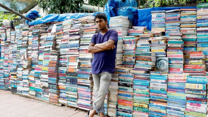 করোনা মহামারির এ সময়ে স্কুল কলেজ বন্ধ থাকায় কমেছে বই বিক্রি। নগরীর নীলক্ষেত পুরান বইয়ের দোকান খুলে ক্রেতার আশায় বসে আছে এক দোকানি। নীলক্ষেত, ঢাকা। ছবি: হাসান রাজা