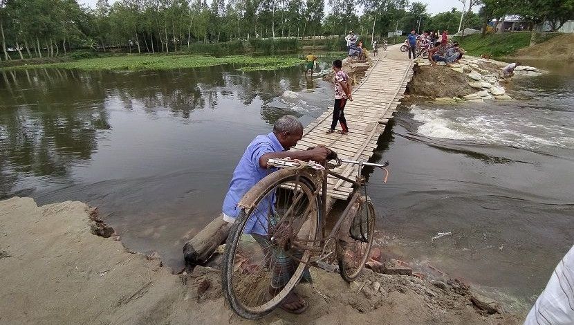 দিনাজপুর জেলার খানসামা উপজেলার বেলান নদীর উপর কইনাডুবি সাঁকোতে প্রতিদিন পারাপার হয় কয়েক হাজার মানুষ। এটিতে সরকারি কোন ধরনের ব্যবস্থাপনা নেই। এলাকাবাসী নিজেরা মিলেই সাঁকোটি নির্মাণ ও সংস্কার করেন। ছবি: মঈন খান